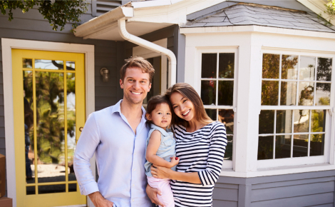 family of three in front of home